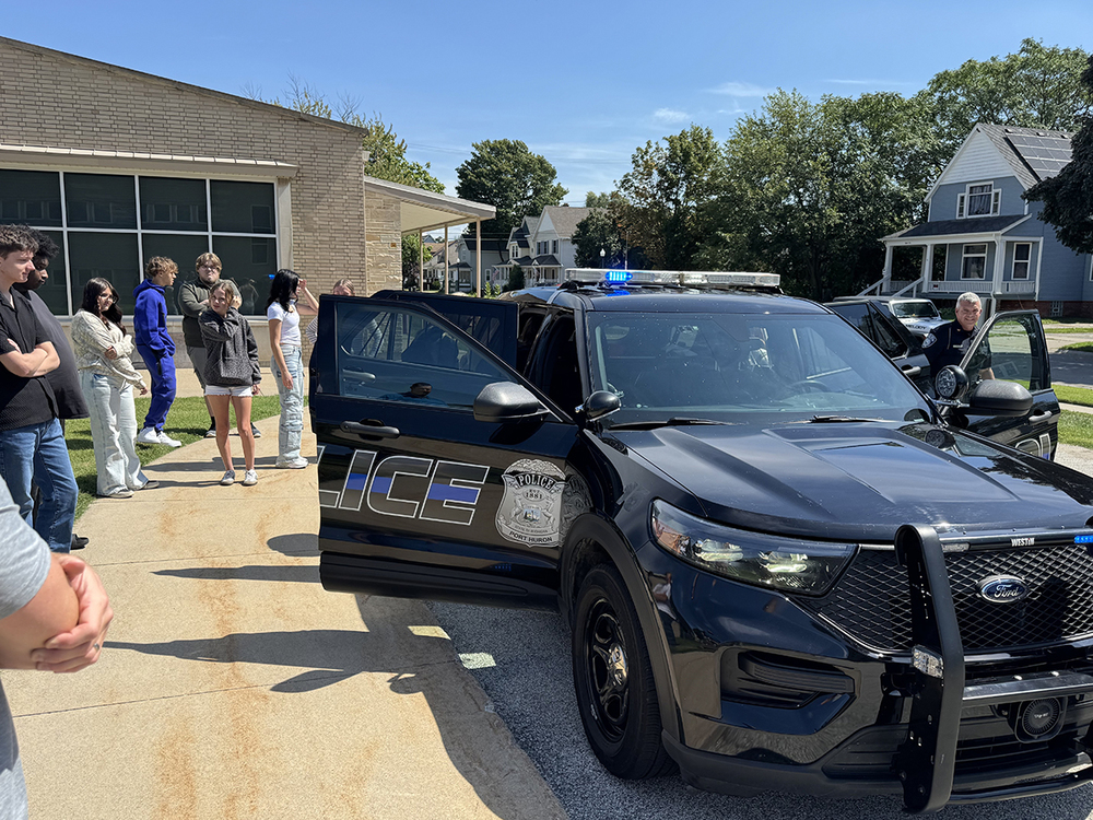 Police Chief Brian Kerrigan and students from St. Clair TEC's Law & Public Safety Program stand next to the retired PH Police cruiser with its doors open