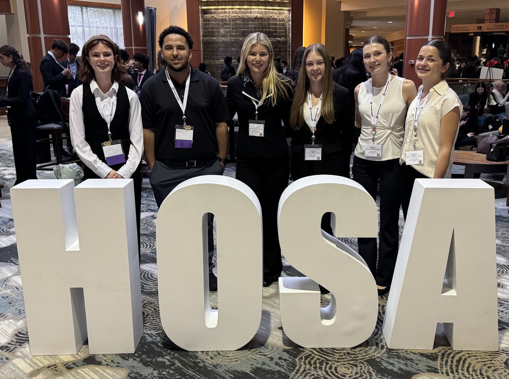 TEC students stand behind tall letters spelling out "HOSA" 