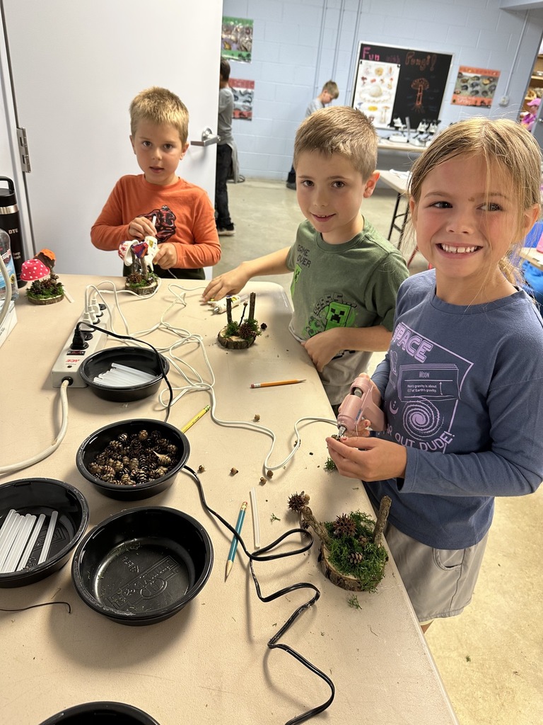 Three children construct fungi creations