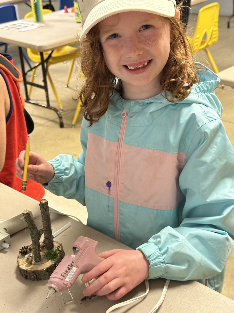 Student gluing branches together