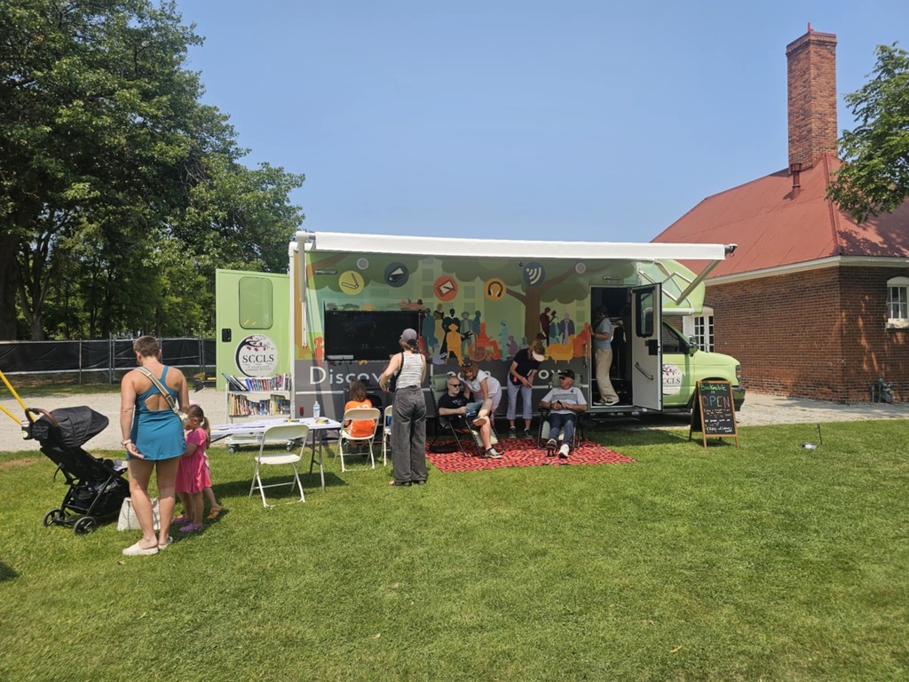 People standing in front of the SCCLS's Bookmobile