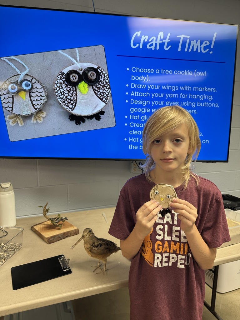 Student holding their owl craft