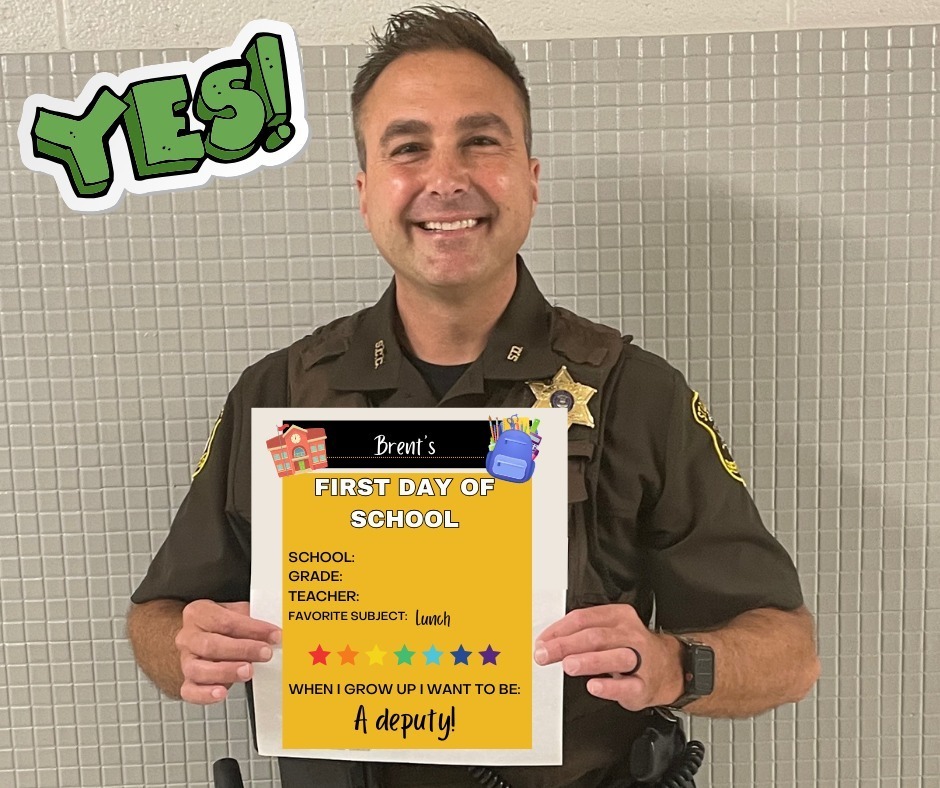 Deputy holding a "First Day of School" sign