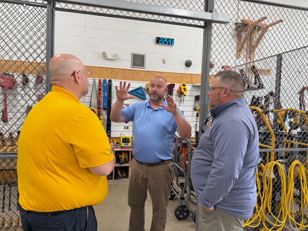 Construction Trades instructor Ken Sygit and representatives from Marshall E Campbell tour the program's tool crib.
