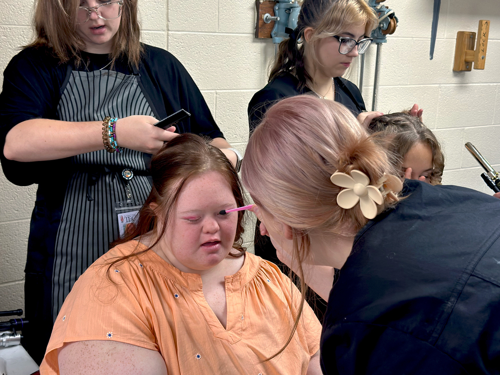 Woodland student getting her makeup and hair done by TEC students in preparation for Fash Bash