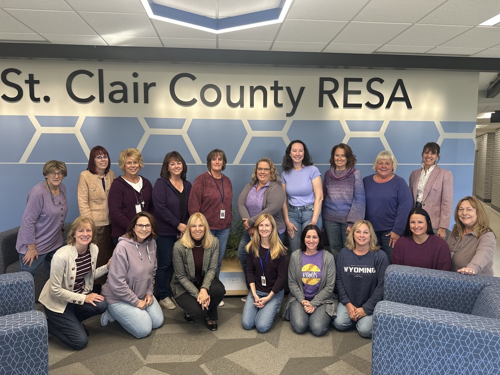 Administration Building staff wearing purple pose in the building lobby
