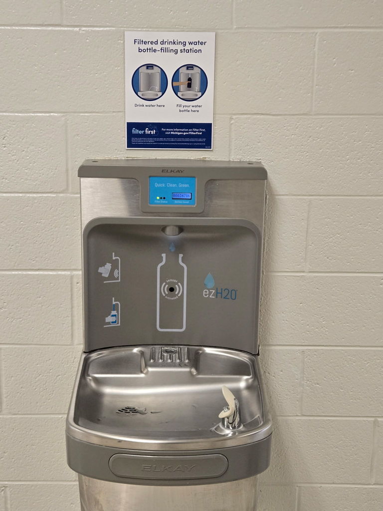A water filling station with a sign reading, "Filtered drinking water bottle-filling station."