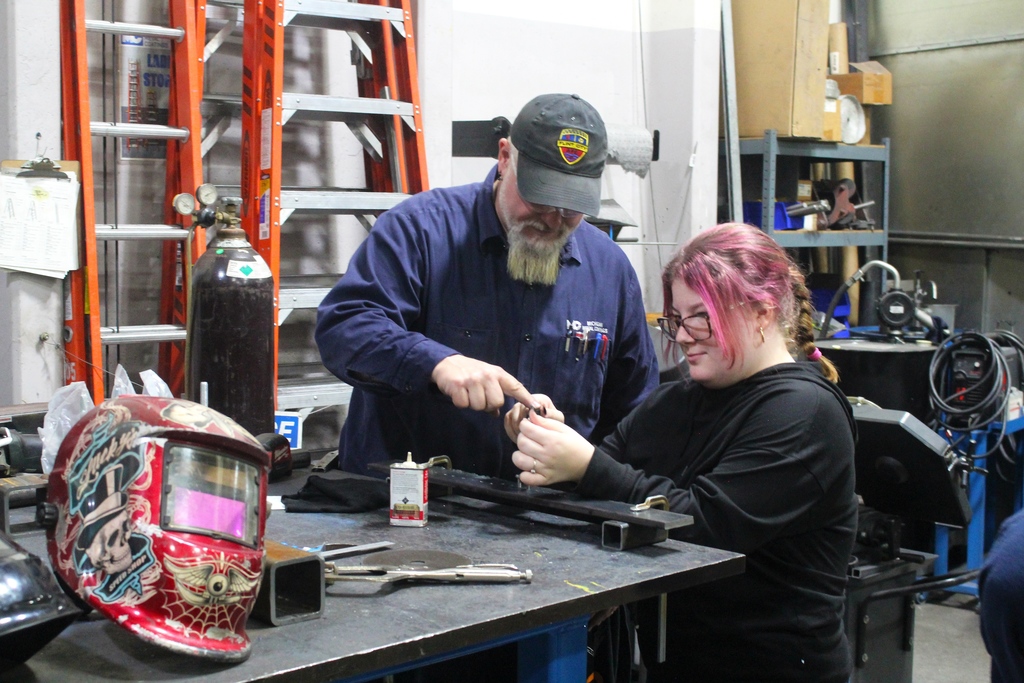 Students at Michigan Metal Coatings, directed by staff, get hands-on experience guiding screws through drilled holes in metal