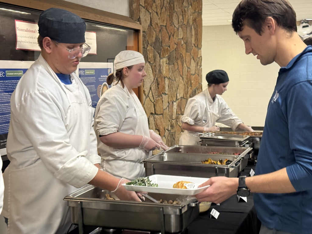 A TEC Culinary Arts student serves a food to a person