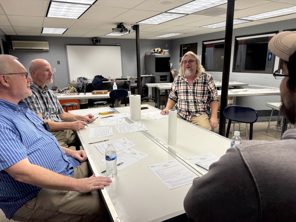 Four adults seated at a table conversing