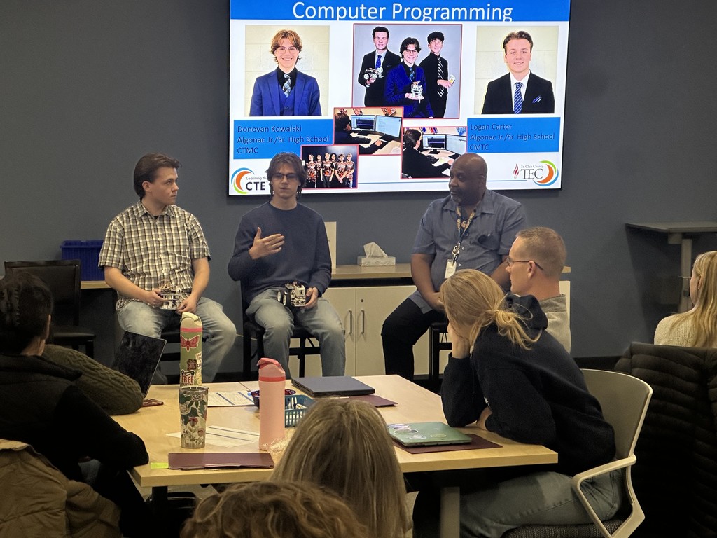 Two TEC students and their instructor seated, speak to a room of people at the December 3 Counselor Networking Meeting at RESA