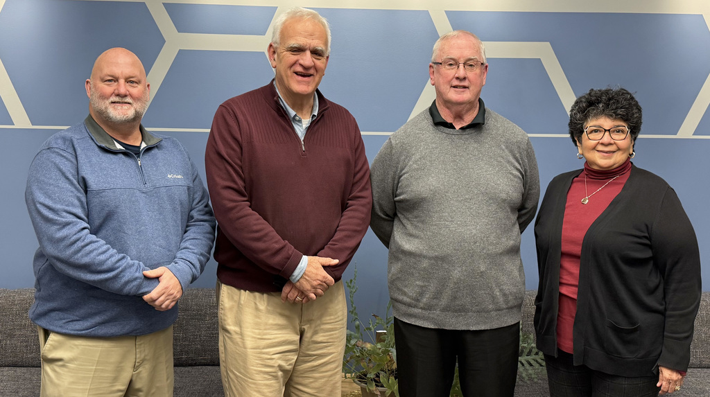 Four members of the St. Clair County Board of Education stand indoors in front of a St. Clair County RESA wall sign. From left to right, Ken Nicholl, Jeff Wine, Mike McCartan, and Jessica Totty