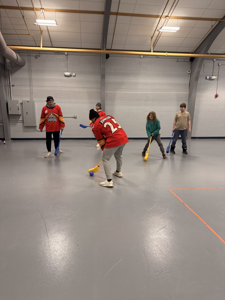 Three Prowlers players and two students play hockey in the school gym