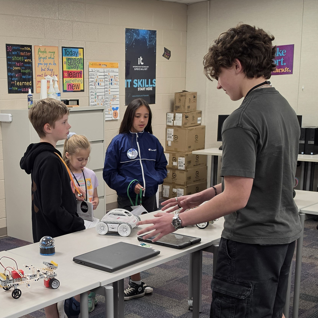 A TEC student demonstrates a robot to three TYCTW day participants