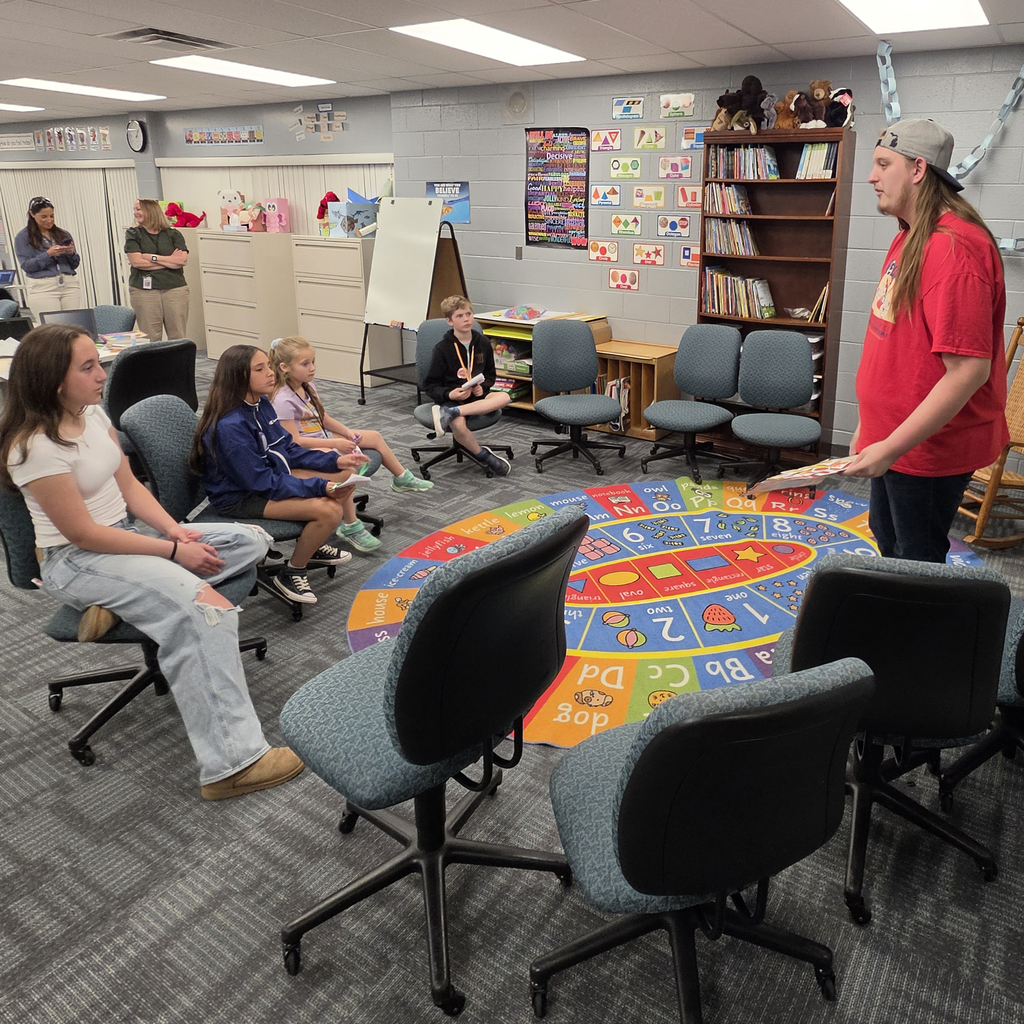 Students sit listening to a  Education program student at TEC