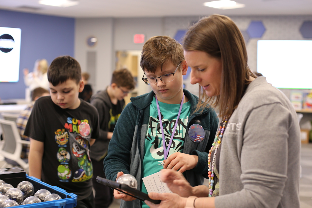 A RESA staff member helps a student program a robot