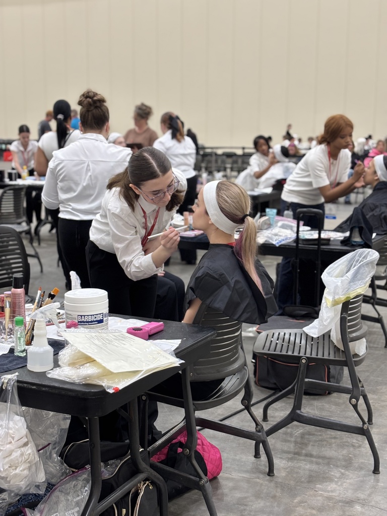 A TEC Cosmetology students paints the face of another student