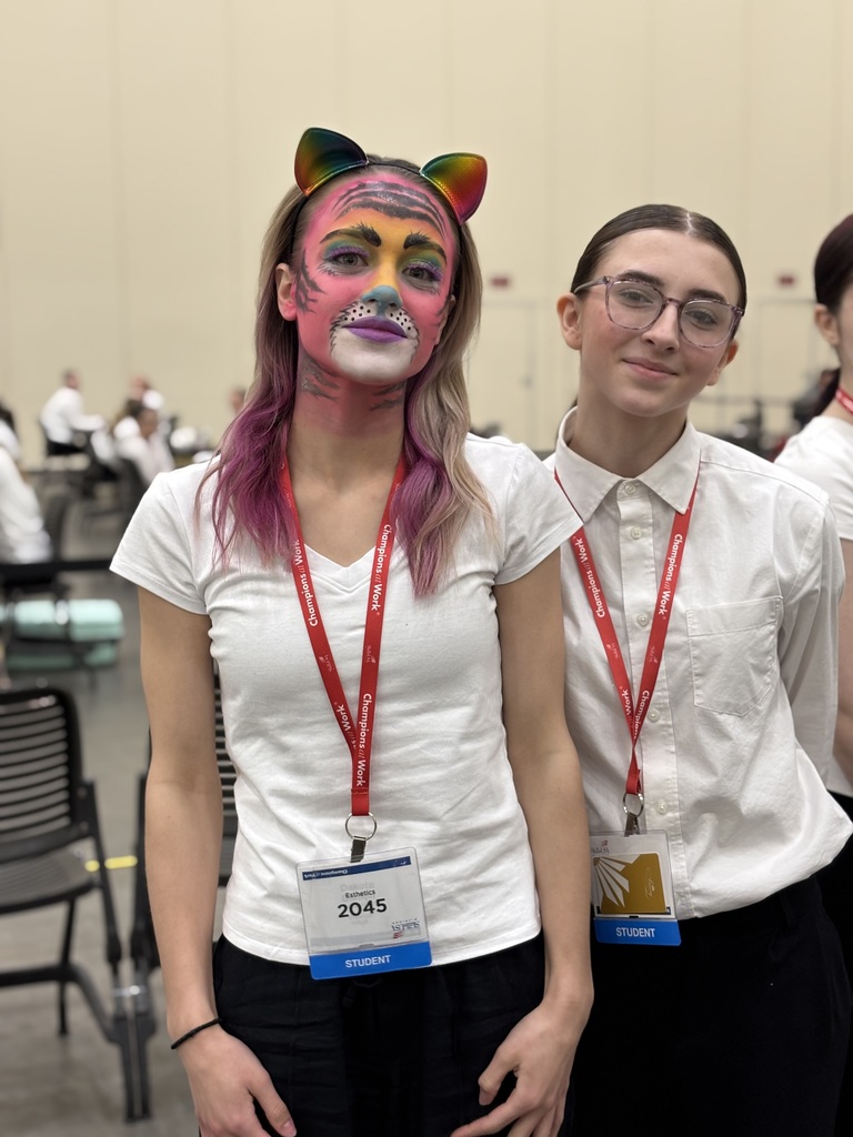 Two TEC students pose, one with a face painted as a colorful tiger