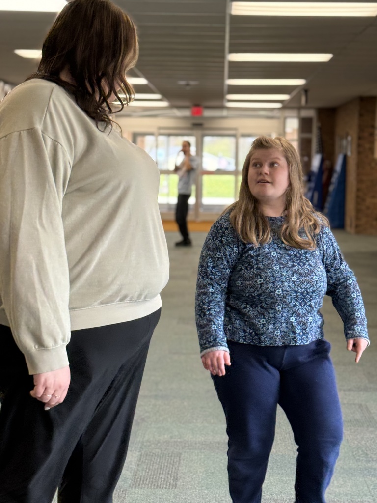 A staff member talking with a student in the school hallway