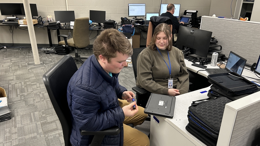 A TEC student observes laptop repair techniques alongside a SCCRESA IT staff member 
