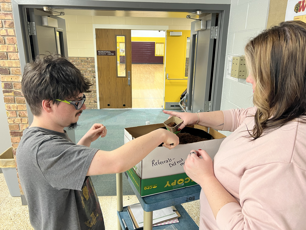 A student and staff member work together to fill a planter with soil during Woodland Developmental Center’s Garden Club activity.