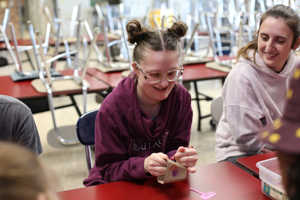 A student smiles while decorating a personalized flower planter during Woodland Developmental Center’s Garden Club.