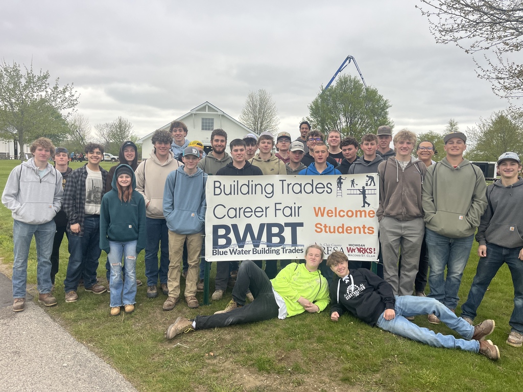 A large group of St. Clair TEC students pose together outside behind a sign reading "Building Trades Career Fair, Welcome Students."