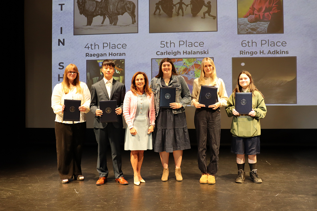 TEC students holding their awards, stand on stage with Lisa McClain