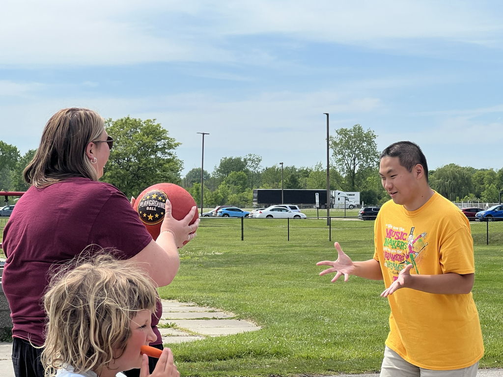 A Woodland staff member tosses a basketball to a students who outstretched hands