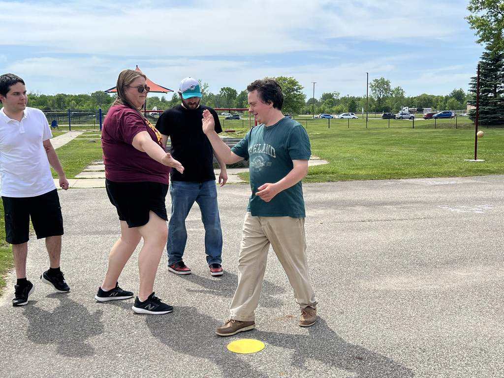 A Woodland staff member high-fives a student as other students look on
