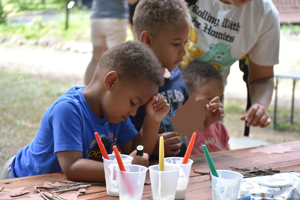 Young children sit at a table painting