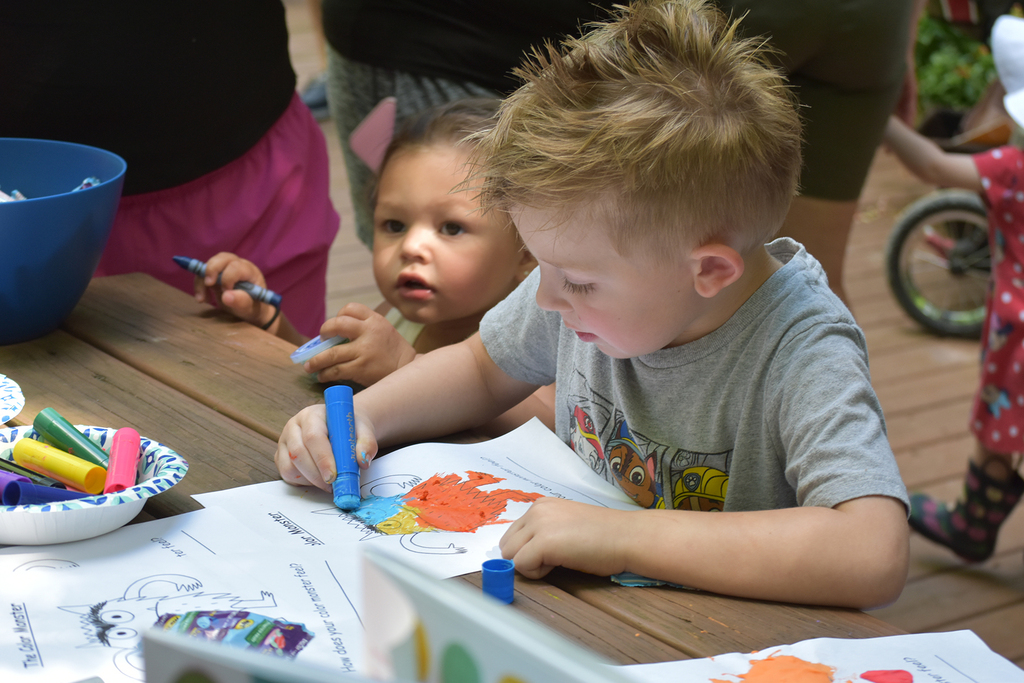 Young children sit at a table coloring