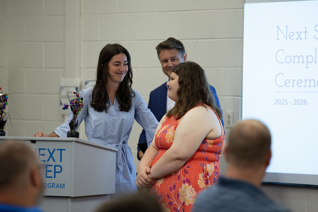 Next Step staff present a student with their completion certificate