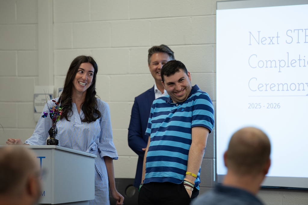 A Next Step student smiles as they receive their completion sertificate