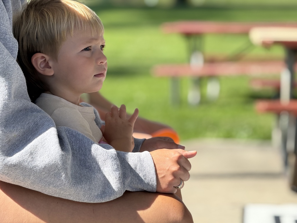 A young child sits on their parent's lap during the PBS-sponsored playgroup 
