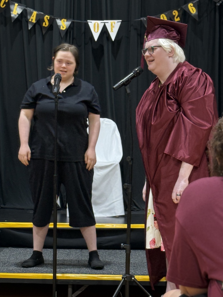 Two Woodland students standing in front of microphones sing a duet