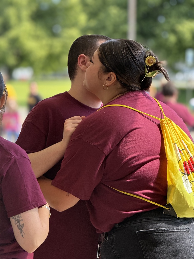 A Woodland staff member hugs a completer in front of the school