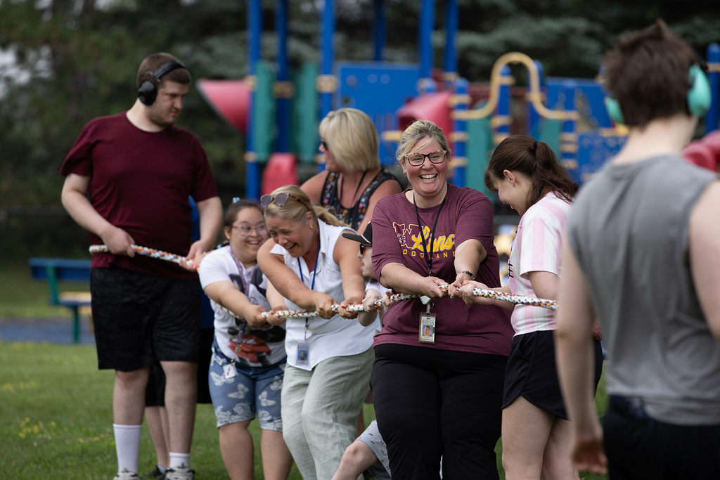 Woodland staff and students hold a rope during a tug-of-war contest during the school's field day