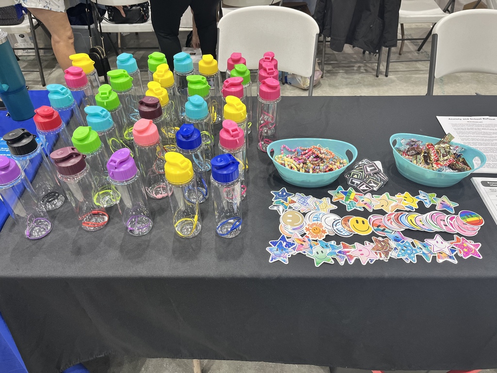 Colorful water bottles, stickers, and candy displayed on a table