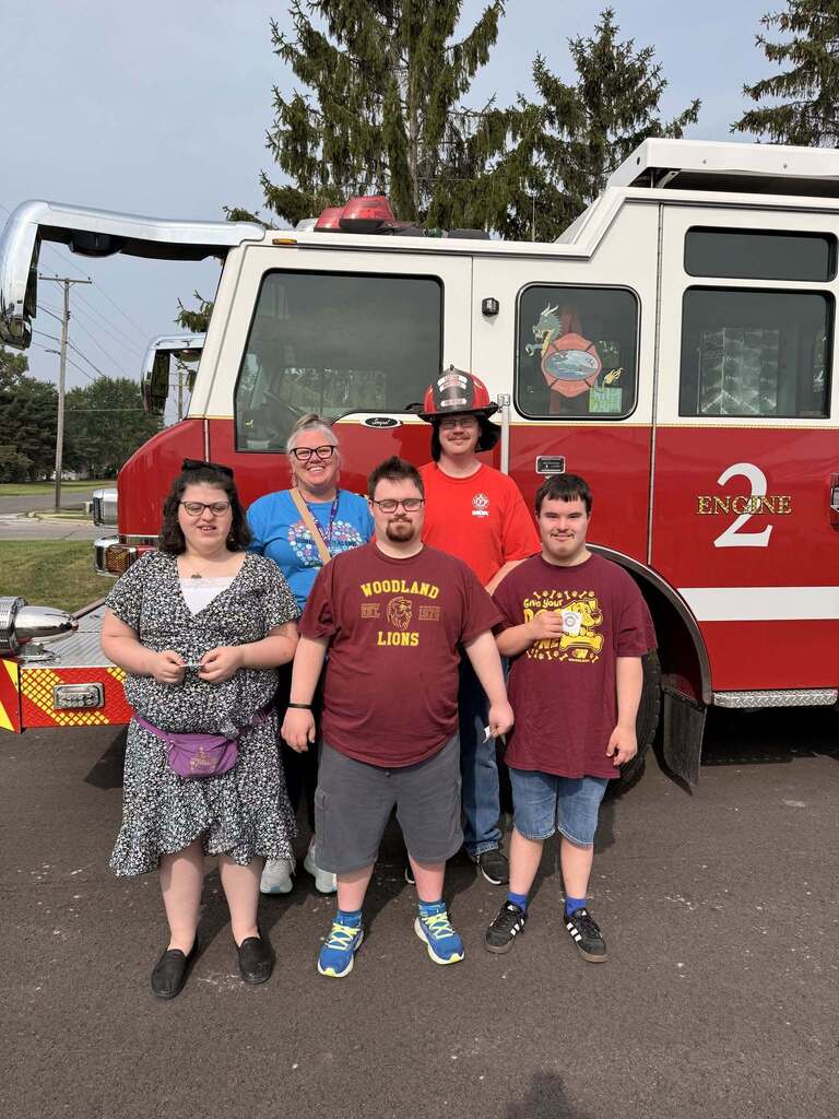 Woodland students and staff pose with a first responder in front of a fire truck