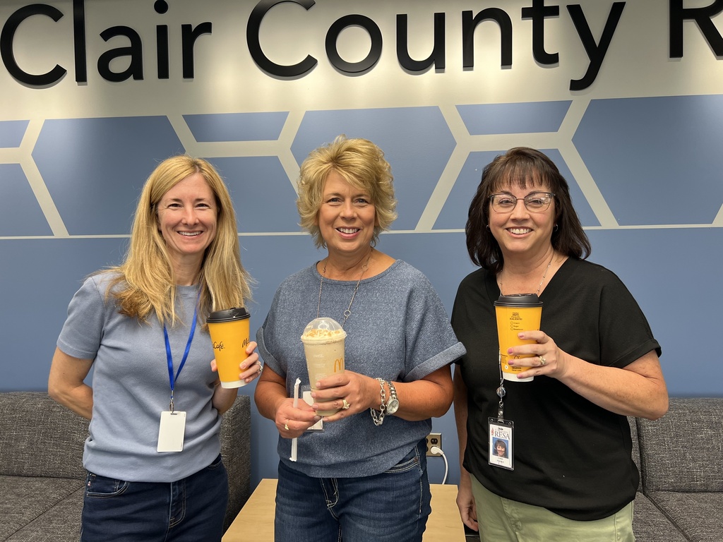 Three RESA staff members holding McDonalds beverages pose in the RESA Administration Building