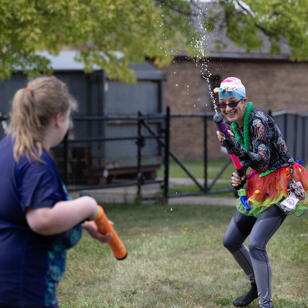 A Woodland staff member holds sprays water on a student