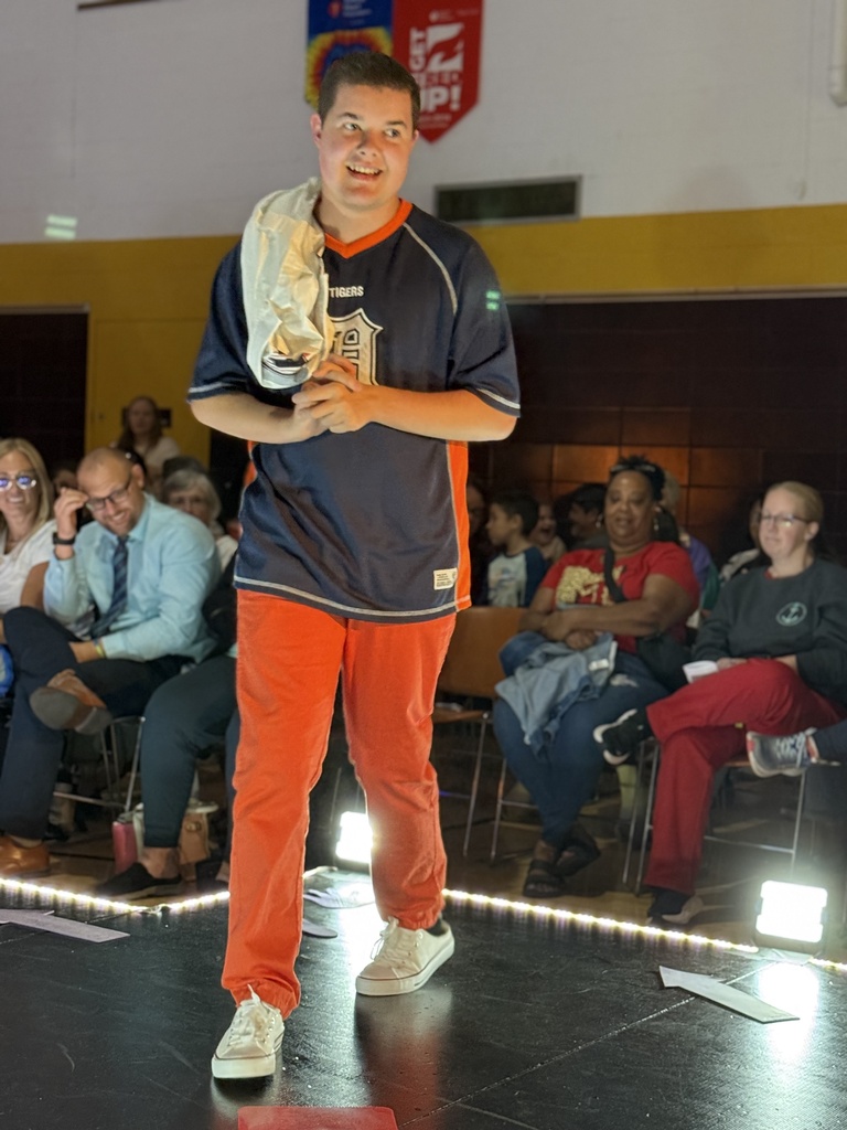 A Woodland student wearing a Detroit Tigers jersey with matching orange pants walks down a raised runway