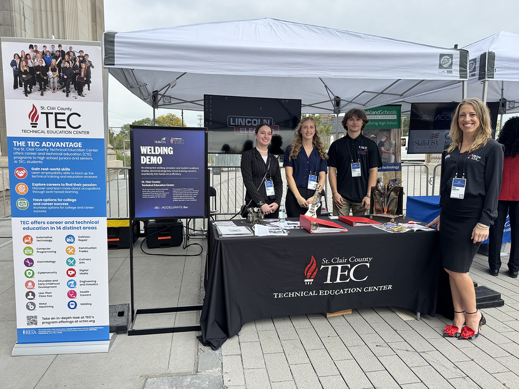 TEC students Allie Stamplis, Rori Cowhy, and Brayden Fontenot stand with Welding instructor Becca Robertson at their booth at Ford Accelerate 