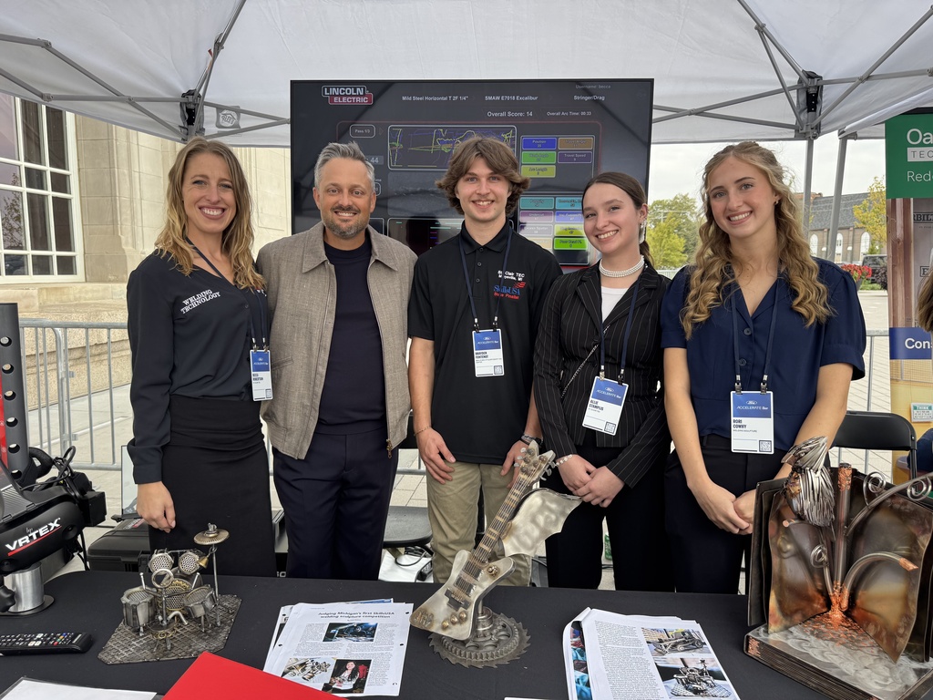 Welding instructor and welding students Brayden Fontenot, Allie Stamplis, and Rori Cowhy pose with Nate Bargatze at Ford Accelerate