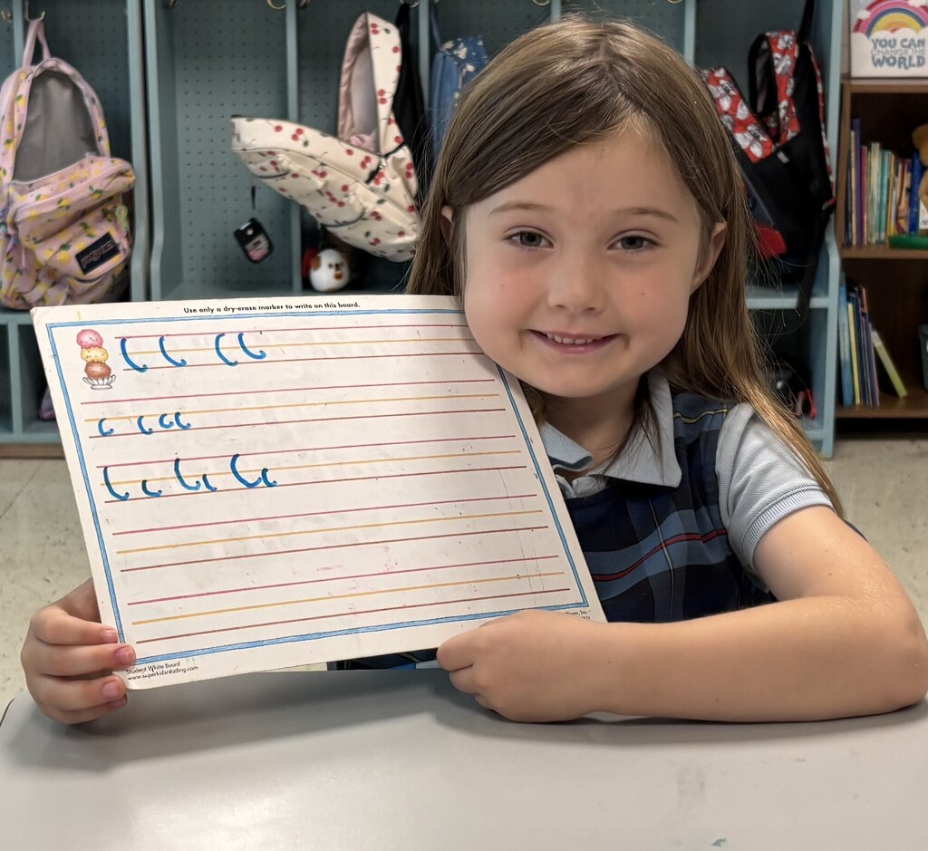 Girl showing off letter C handwriting