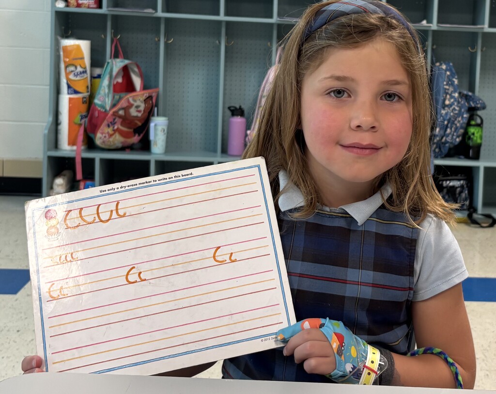 GIrl showing letter C practice