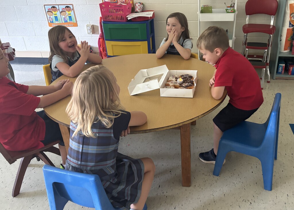 Students gathered around box of donuts