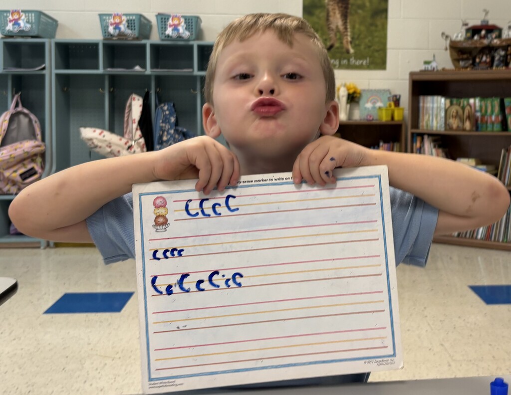 Boy showing letter C on whiteboard