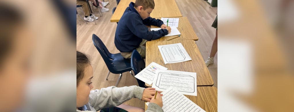 Bellarmine Students at St Edward’s designed and led lessons for our students in grades 2 through 5, this image - Students writing at desks during class.